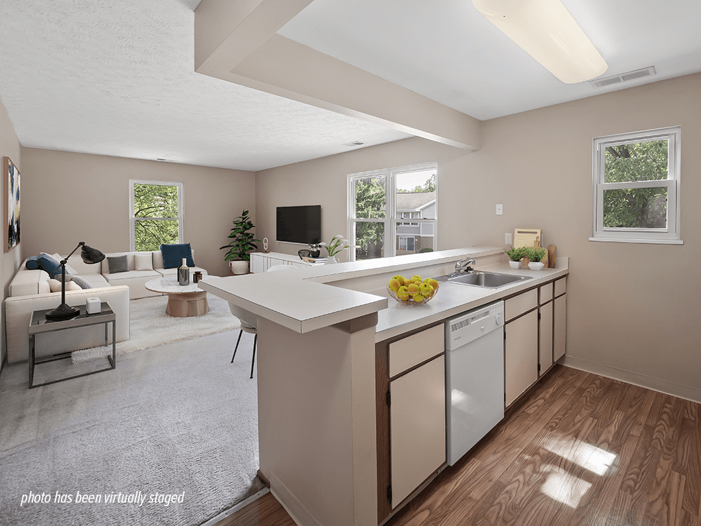 A kitchen with a white countertop and a white dishwasher.
