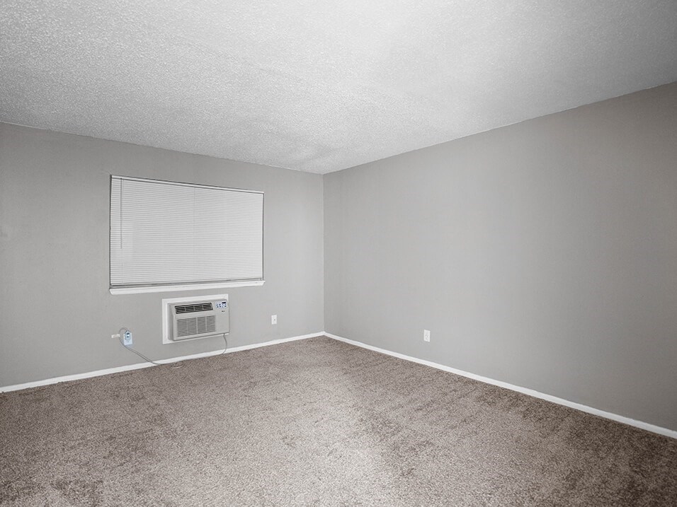 an empty room with a window and a radiator
