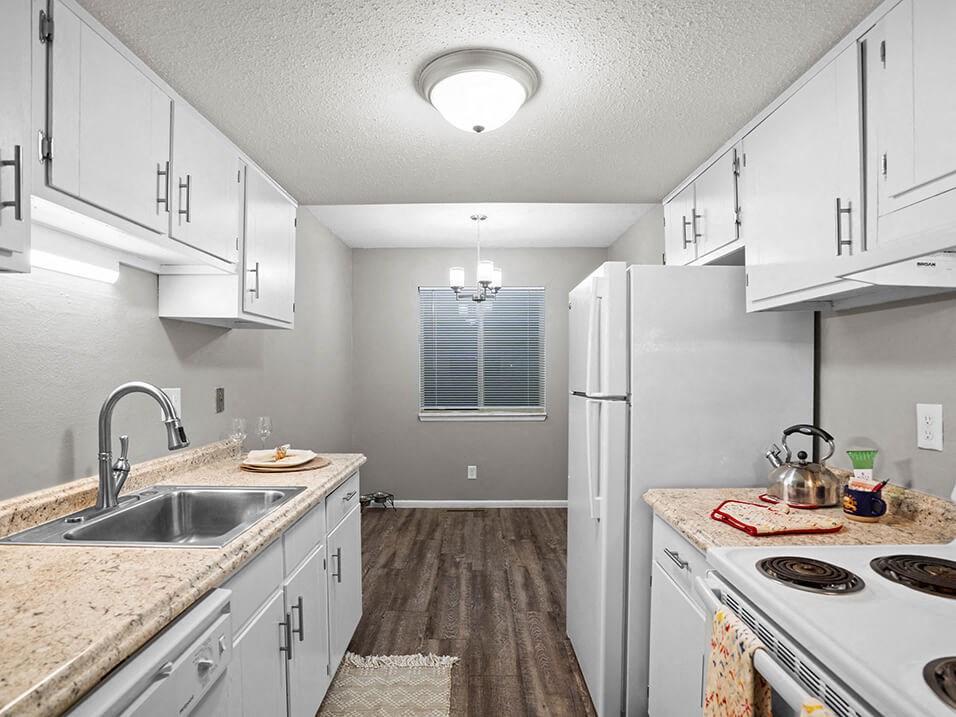 a kitchen with white cabinets and a sink and a refrigerator