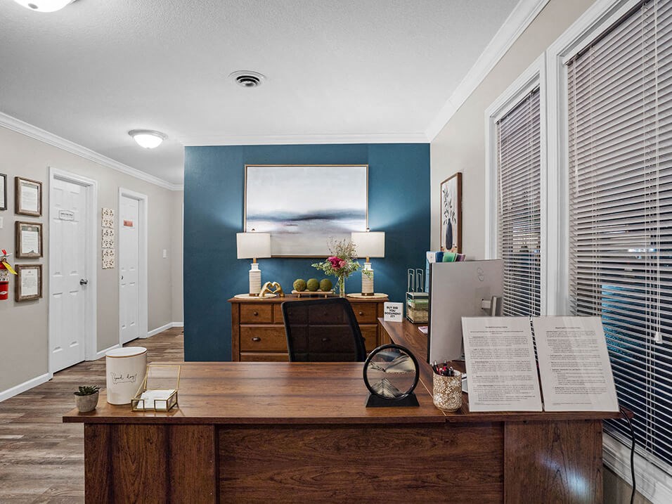 a office with a desk and a painting on the wall