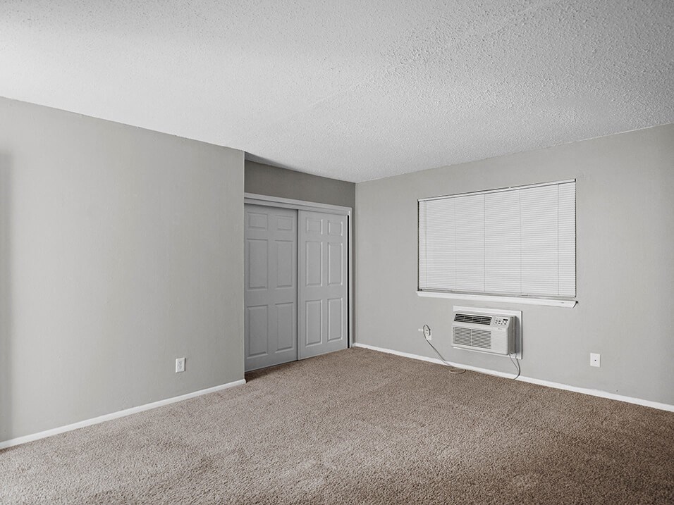 an empty living room with a window and a door