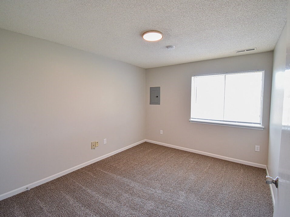 Carpeted bedroom with window