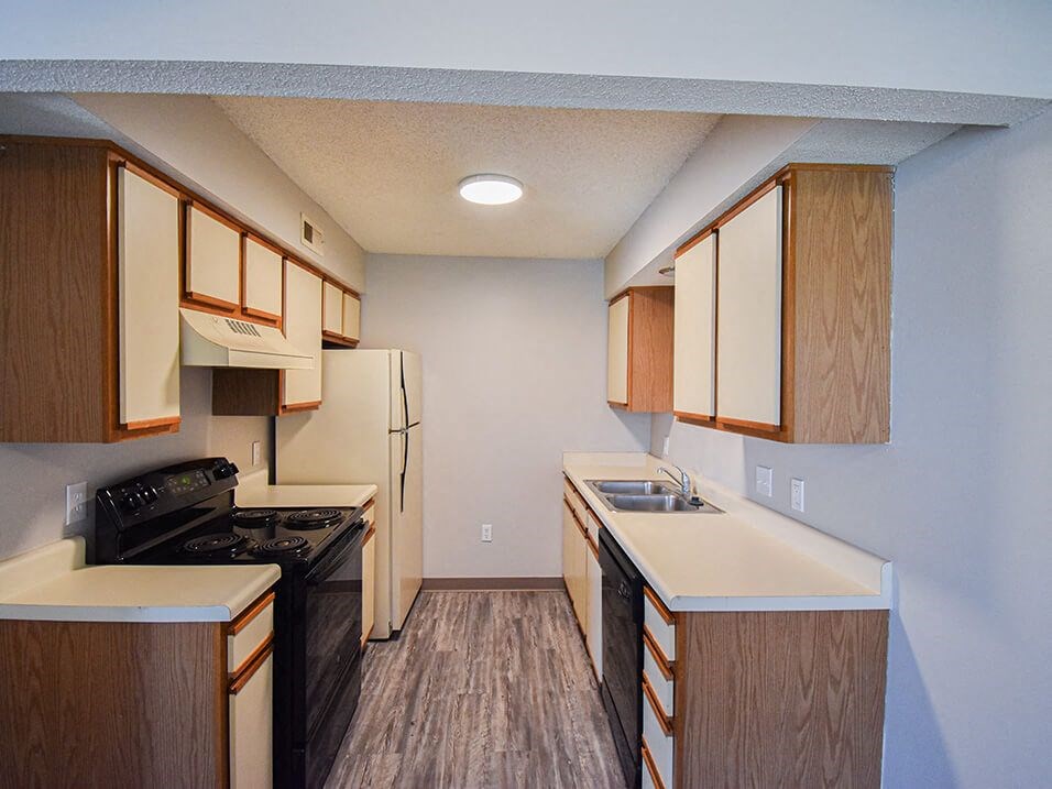 Kitchen with white cabinets, refrigerator, oven, and dishwasher