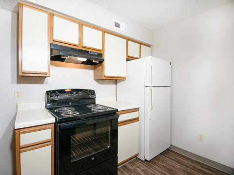 A kitchen with a black stove and white cabinets.