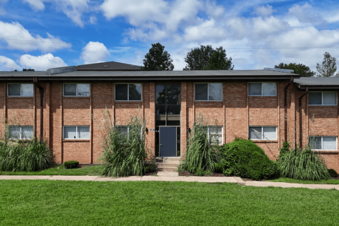 A red brick building with a black door and windows.