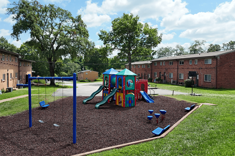 A playground with a slide, swings, and a sandbox.
