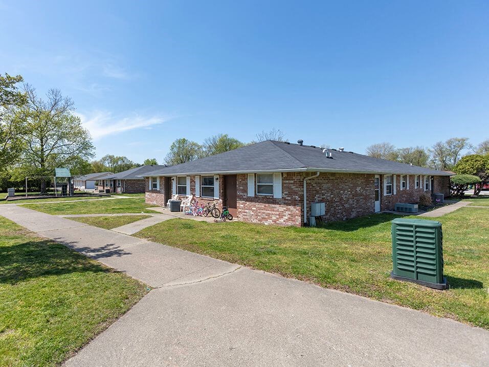 a brick house with a sidewalk in front of it