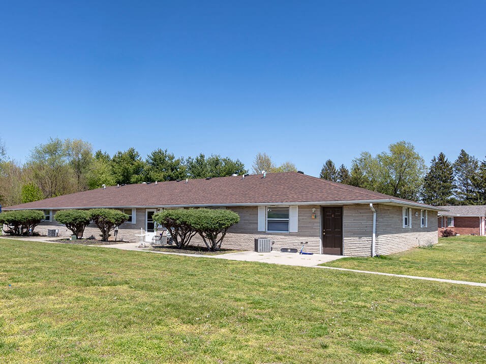 a house with a lawn and trees in front of it