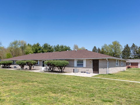 a house with a lawn and trees in front of it