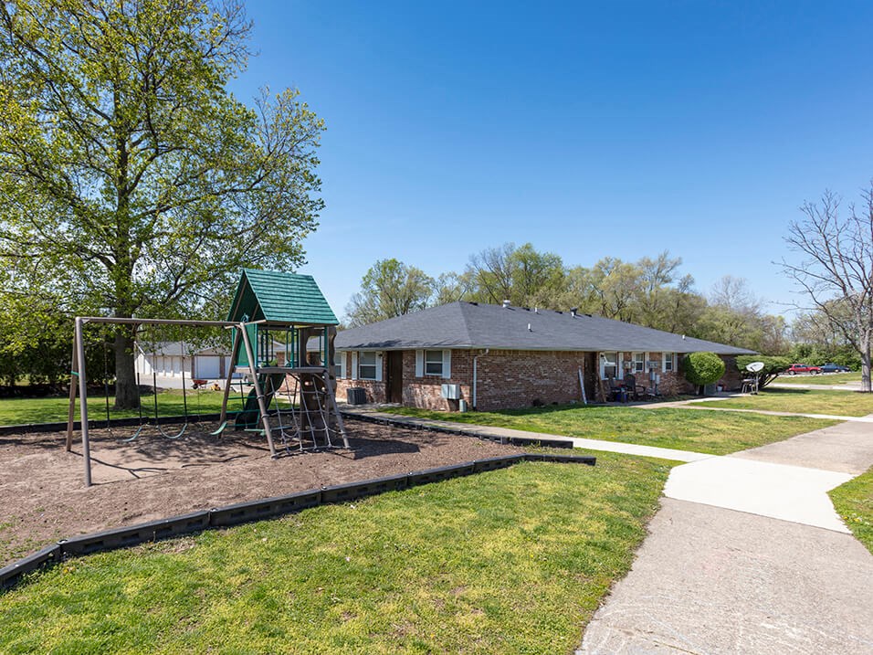 a playground in a yard in front of a house