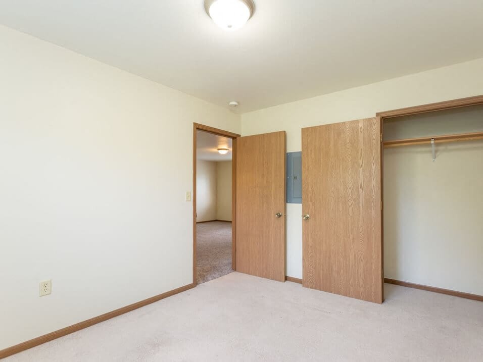 a bedroom with two doors and a carpeted floor