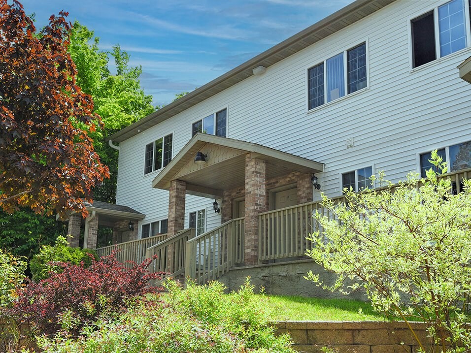 a large white house with a wooden porch and stone pillars