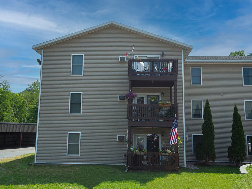 the back of a house with a balcony and an american flag