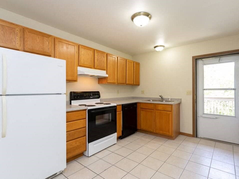 a kitchen with a refrigerator freezer and a stove top oven
