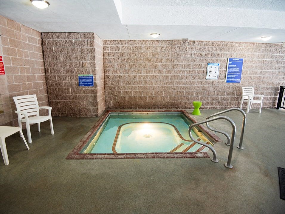 a hot tub in a room with chairs and a table
