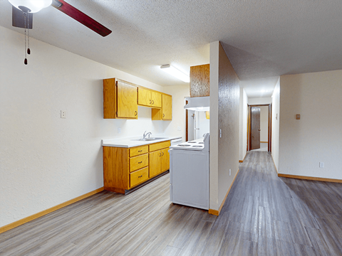 A kitchen with wooden cabinets and a white counter.