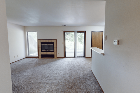 A living room with a fireplace and sliding glass doors.