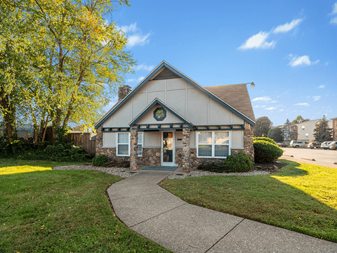 the front of a house with a sidewalk and grass
