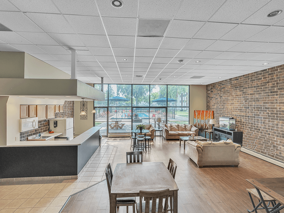 a dining room with tables and chairs and a living room with couches and chairs