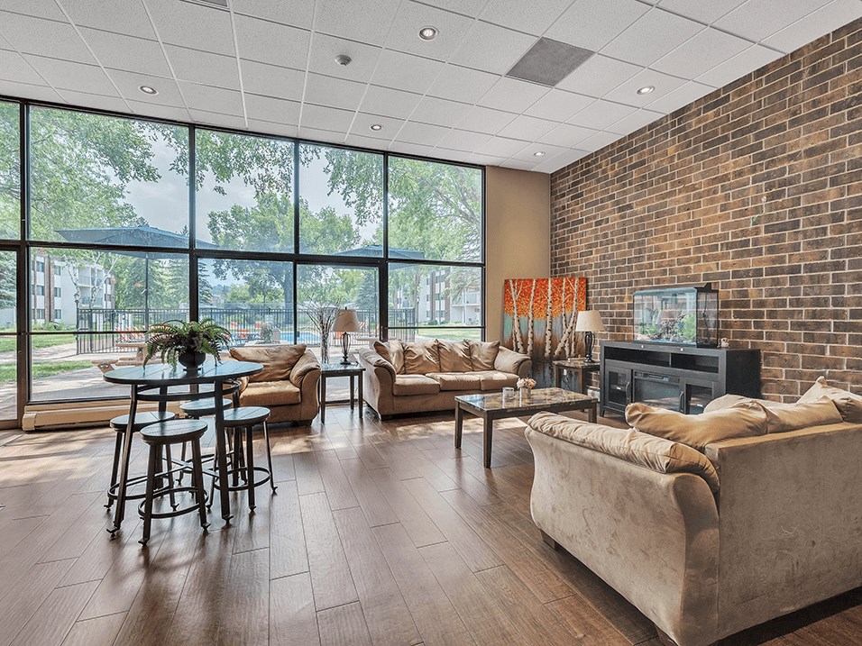 a living room with couches and a table in front of a wall of windows