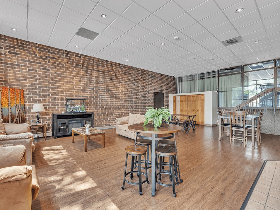 a living room with a couch and a table in front of a brick wall