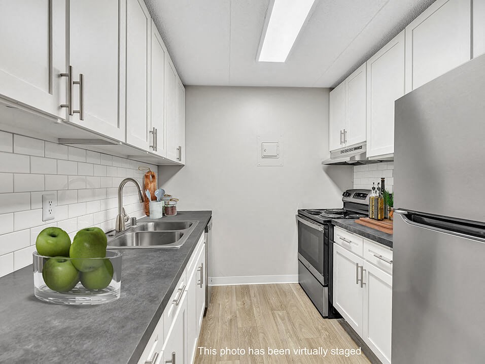 a white kitchen with stainless steel appliances and white cabinets