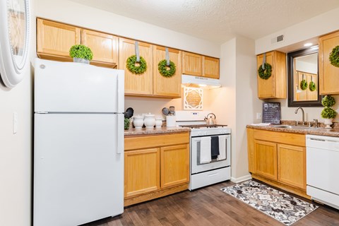 A kitchen with wooden cabinets and a white fridge.