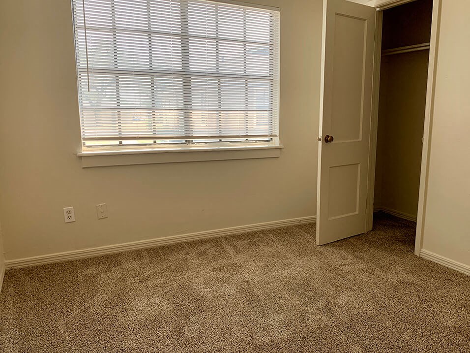 a bedroom with a large window and a door