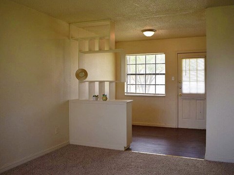 an empty living room with a door and a window