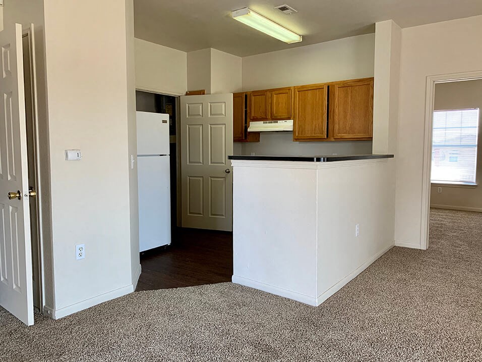 a kitchen with a white refrigerator freezer next to a doorway