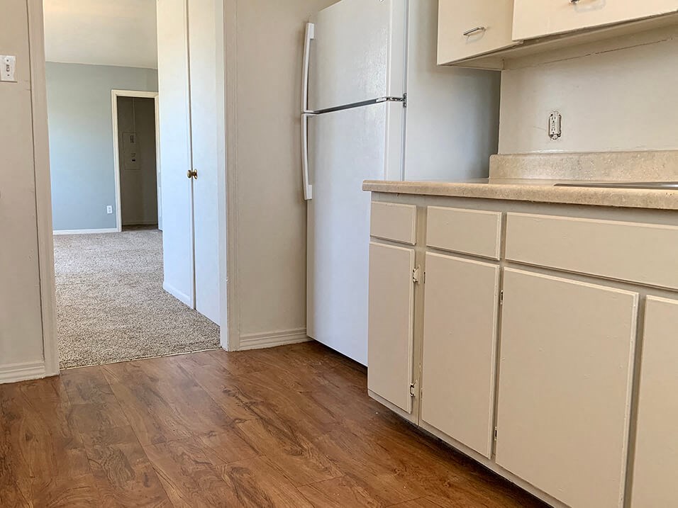 a kitchen with white cabinets and a white refrigerator