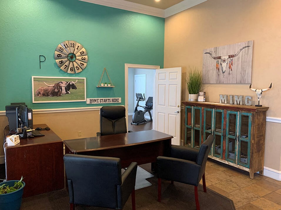 an office with a desk chairs and a clock on the wall