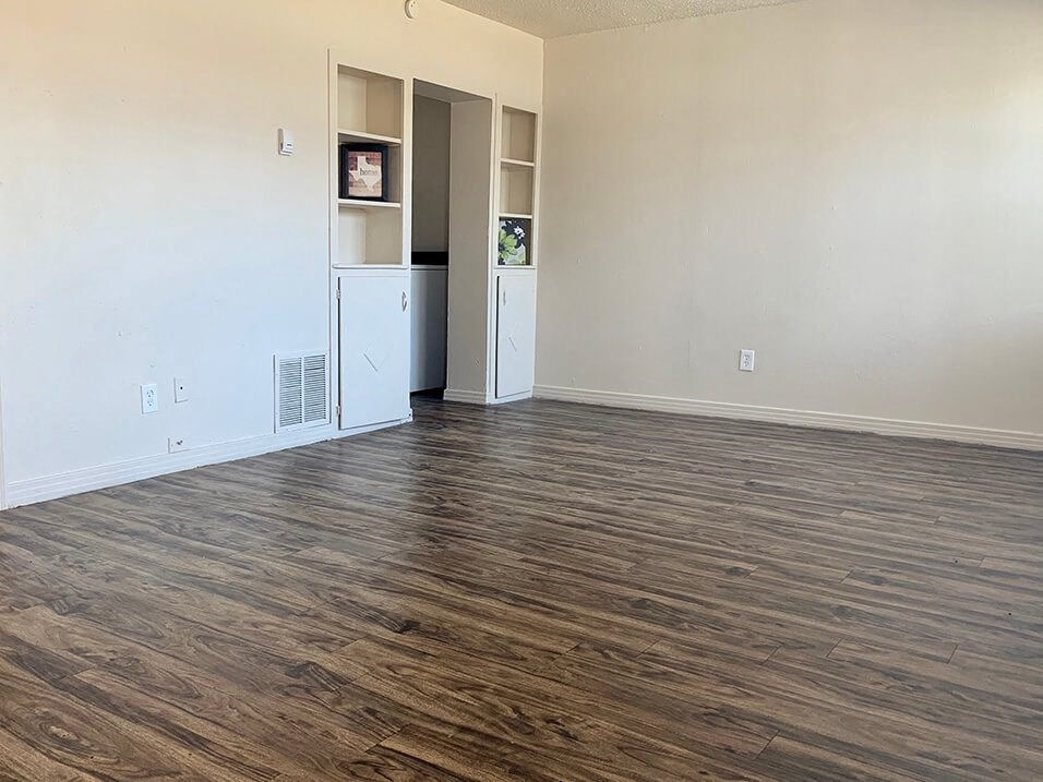 a living room with a refrigerator and a bookshelf