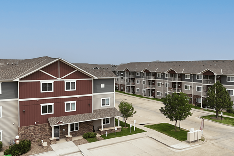 Apartment complex with a red building in the foreground.