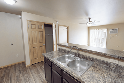A kitchen with granite countertops and a double sink.
