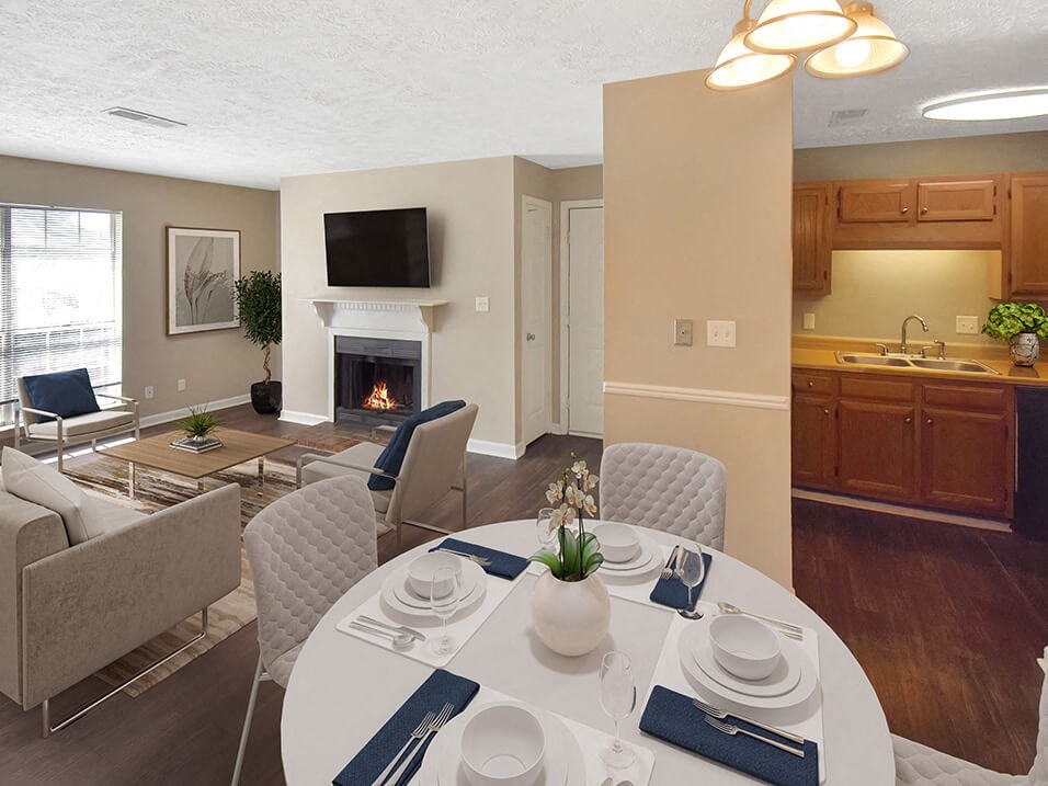 a dining area with a table and chairs and a fireplace in the background