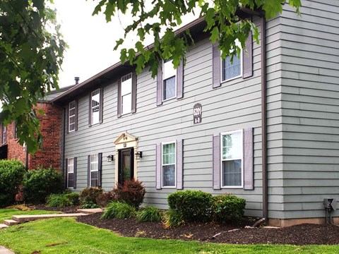 a gray house with a red brick chimney