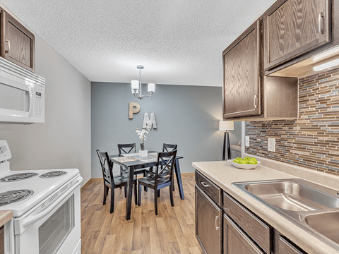 A kitchen with a table and chairs in the middle of the room.