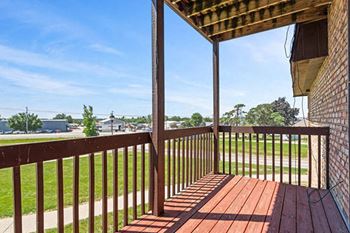 a balcony with a view of a field and a blue sky