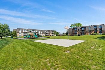 a basketball court in the middle of a grass field
