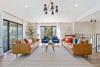 a living room with couches and chairs and a rug