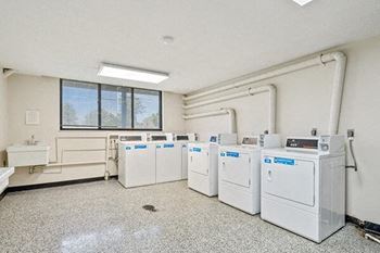 a row of washing machines in an empty room