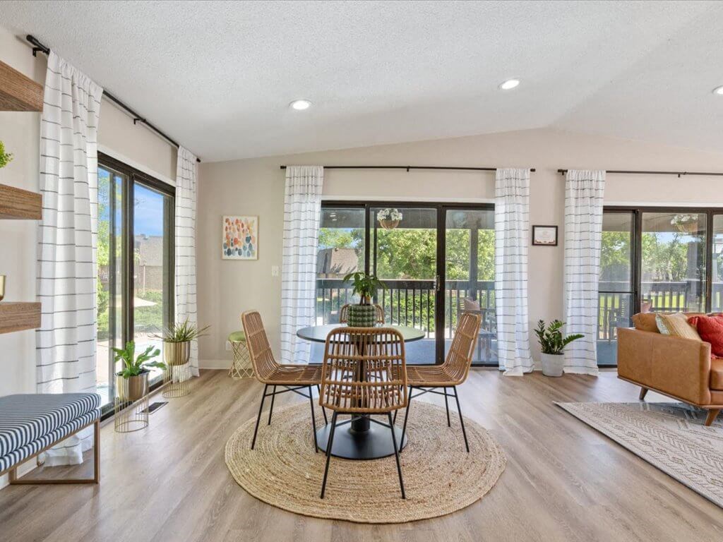 a dining room with a table and chairs and a balcony