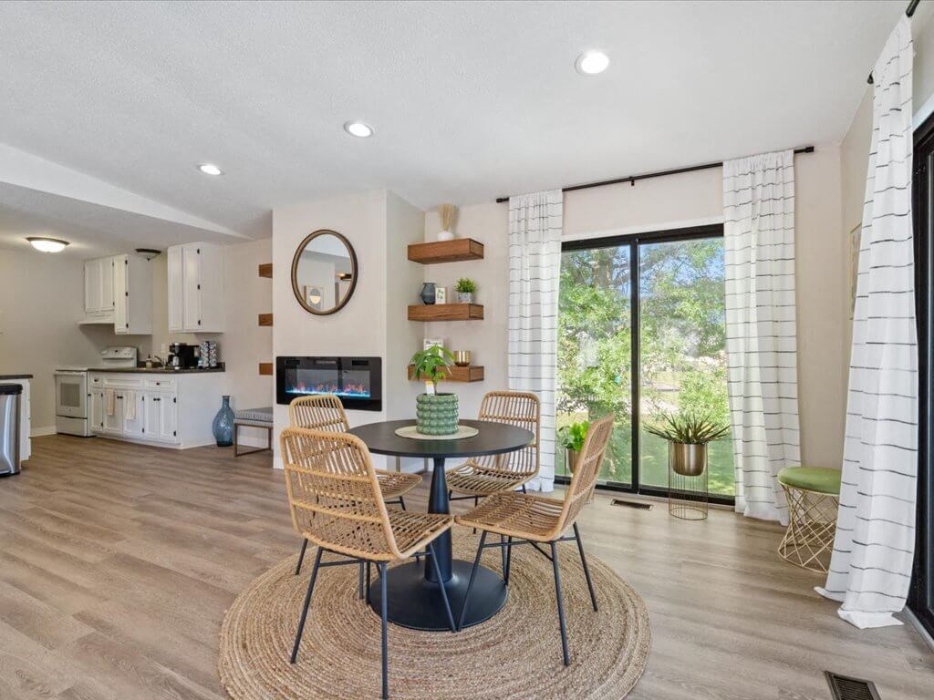 a dining room with a table and chairs in front of a window