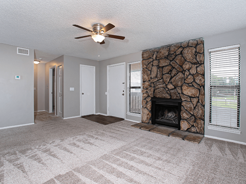 a living room with a fireplace and a ceiling fan