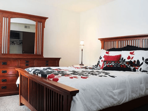 a bedroom with a bed and a dresser and a mirror