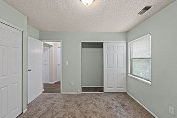 an empty room with white doors and a window