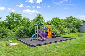 a childrens play area in a yard with playground equipment