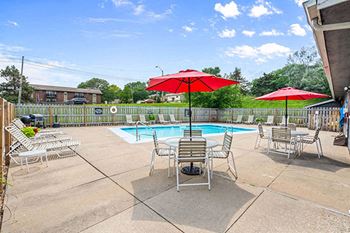 a swimming pool with chairs and umbrellas next to a poolside umbrella