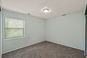 an empty room with a window and a carpet